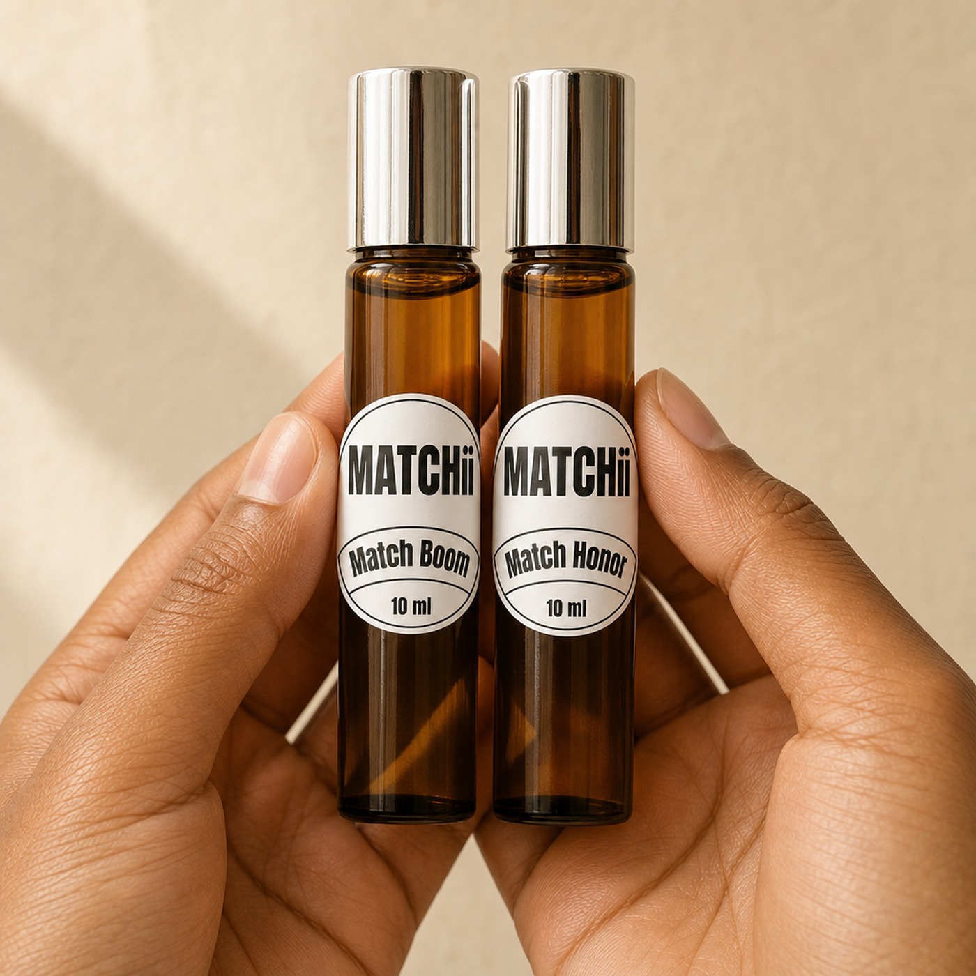 Maos segurando dois perfumes roll-on Matchii para montar um layering